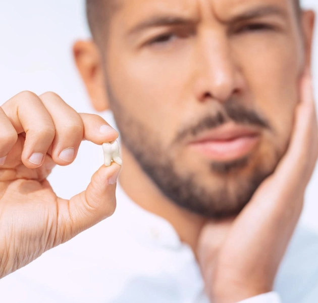 Man examining teeth with finger, concerned expression, white background, dental care context