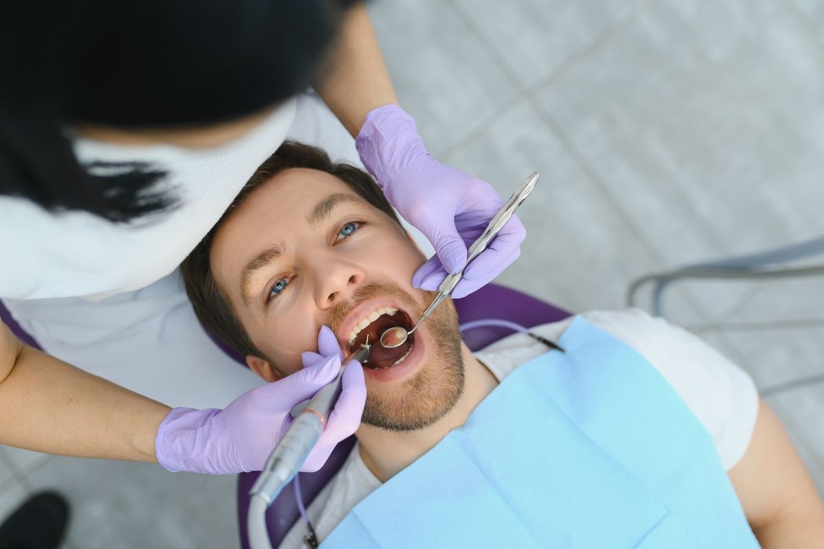 Male patient receiving a dental checkup and cleaning from a dentist in silver spring