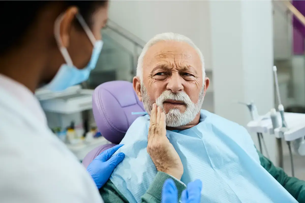 Senior patient experiencing tooth pain during dental consultation with dentist in Silver Spring.