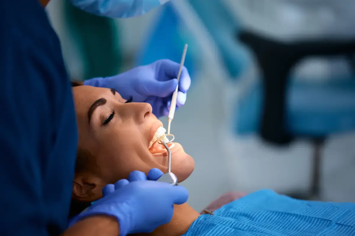 Dentist performing root canal treatment on patient in dental office.